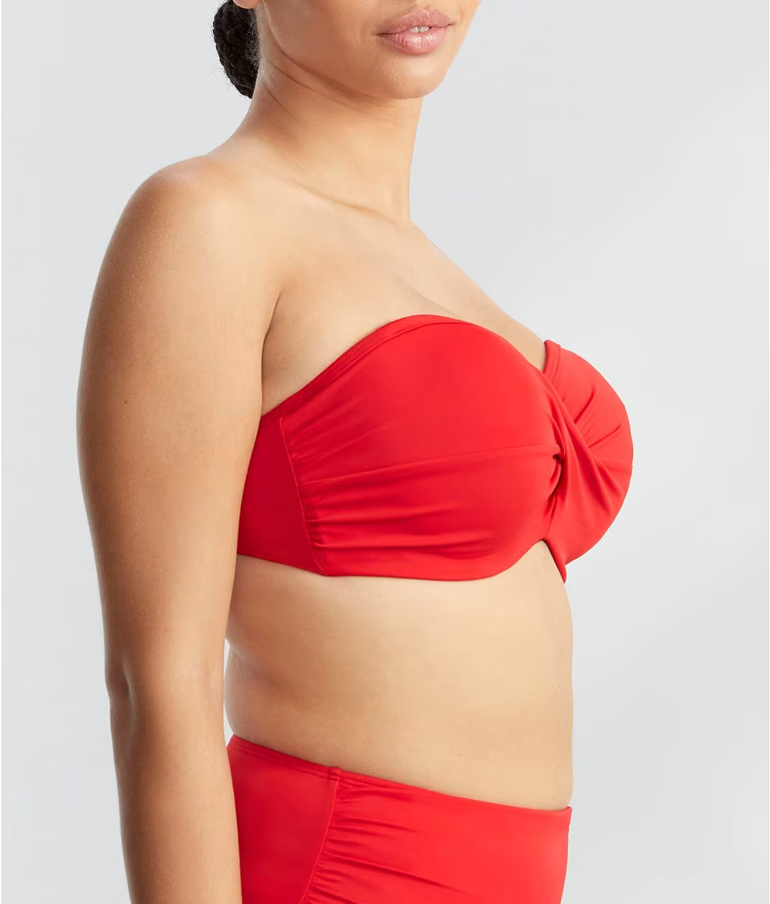 Red bikini top worn by a person on a light gray background