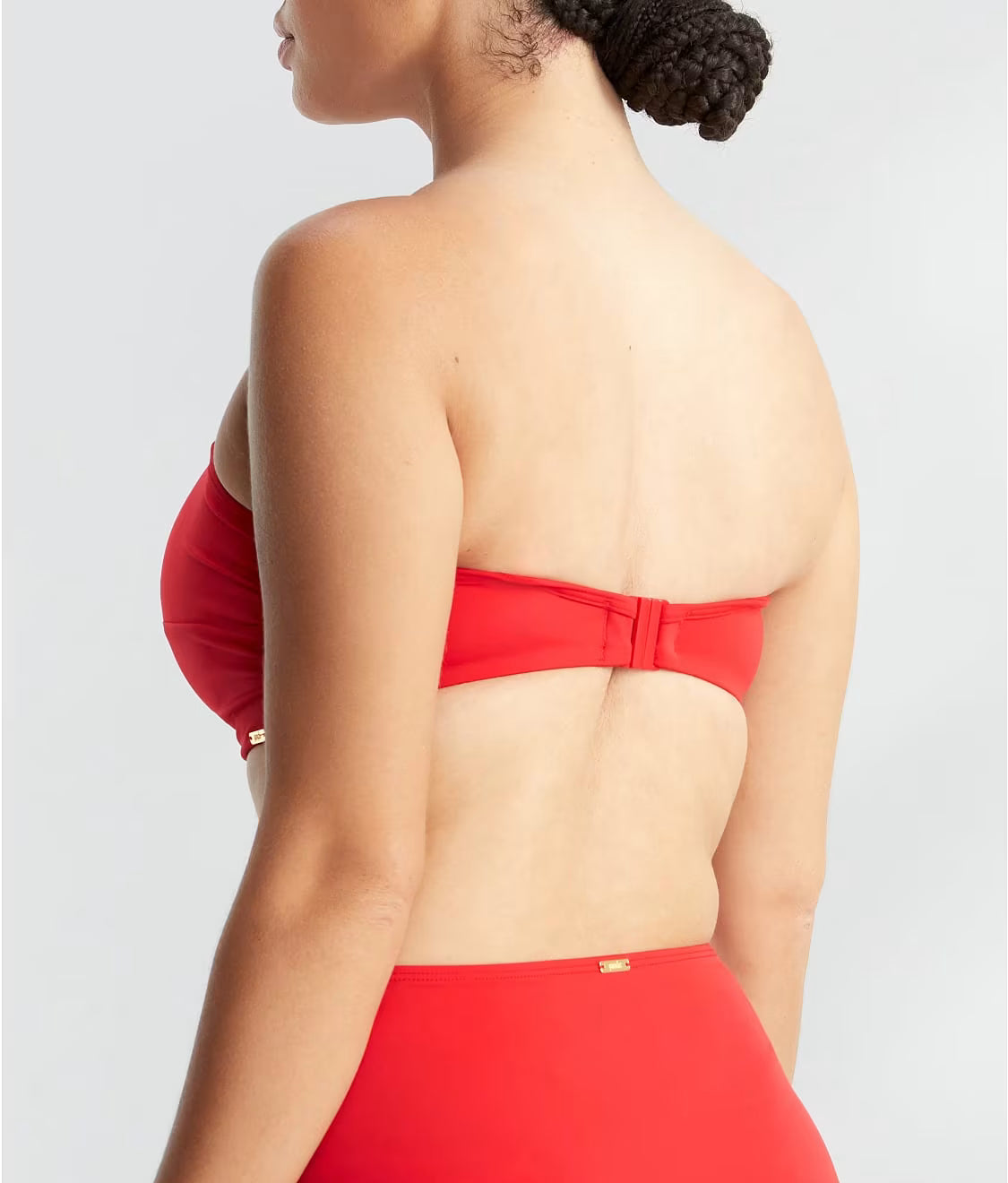 Red strapless top worn by a person on a light gray background