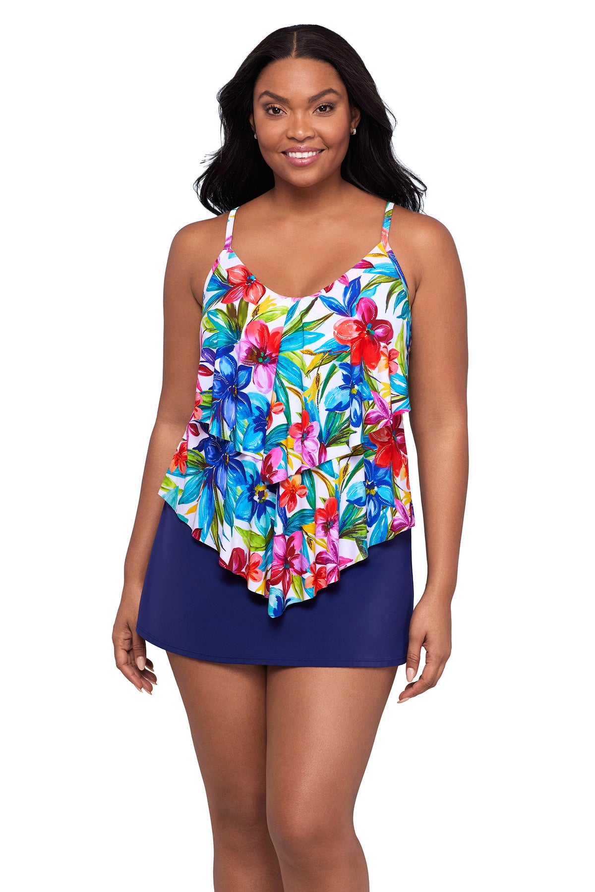 Woman wearing a colorful floral tankini top and navy skirt on a white background
